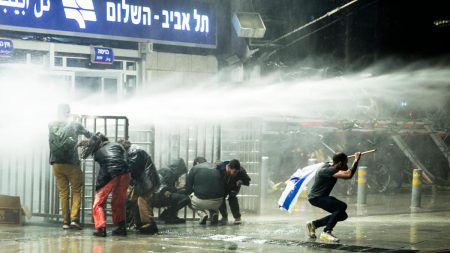 Israeli protesters run as police officers use water canon after clashes erupted during a demonstration against the government's judicial overhaul on March 27, 2023 in Tel Aviv. (Photo by Amir Levy/Getty Images)