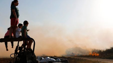 Israeli children look at fire after a kite was reportedly sent by Palestinian protesters from across the border to burn fields in Kibbutz Beeri near the border with the Gaza Strip on June 5, 2018. MENAHEM KAHANA/AFP via Getty Images